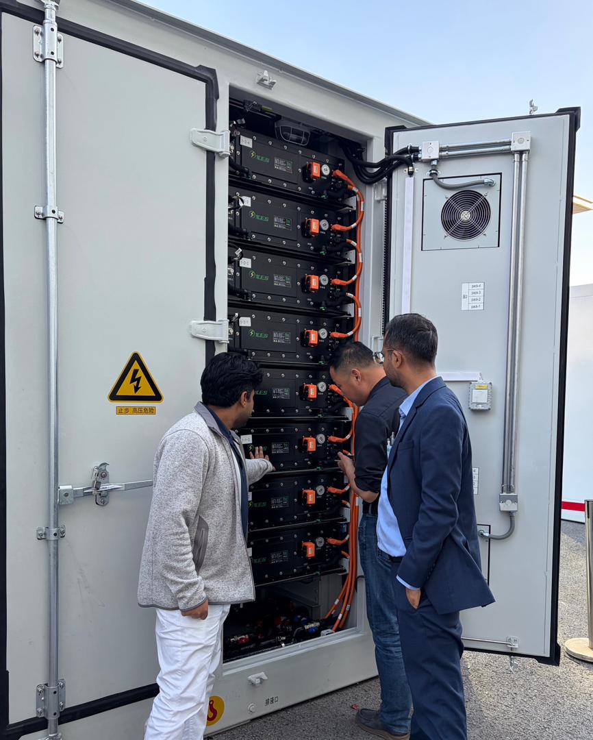 Engineers inspecting battery cabinet